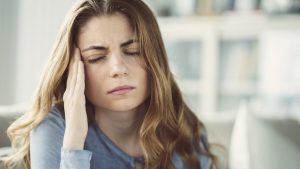 Young woman with headache in home interior