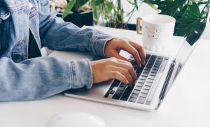 person-using-a-laptop-to-study-on-work-desk-free-photo