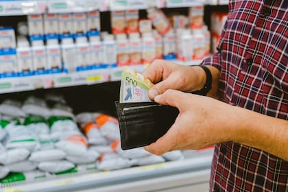 moneyandsupermarketmancountshismoneyargentinepeso-C2H3X6EKSBHYTHBYXRNSVUWAEE